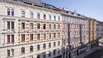 Ein mehrstöckiges Gebäude mit aufwendigen architektonischen Details, darunter Säulen und dekorative Verzierungen.