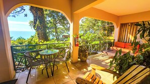 Un balcon avec vue sur la mer, une table, des chaises et un canapé.