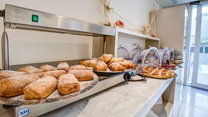 Un bufé con diversas pastas y productos horneados.