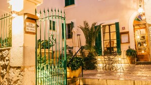 A hotel entrance with a wrought iron gate, a sign indicating it is Hotel El Guía, and steps leading up to the entrance. - Hotel El Guía (Sóller)
