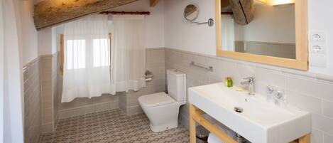 A bathroom with a toilet, sink, and shower area.