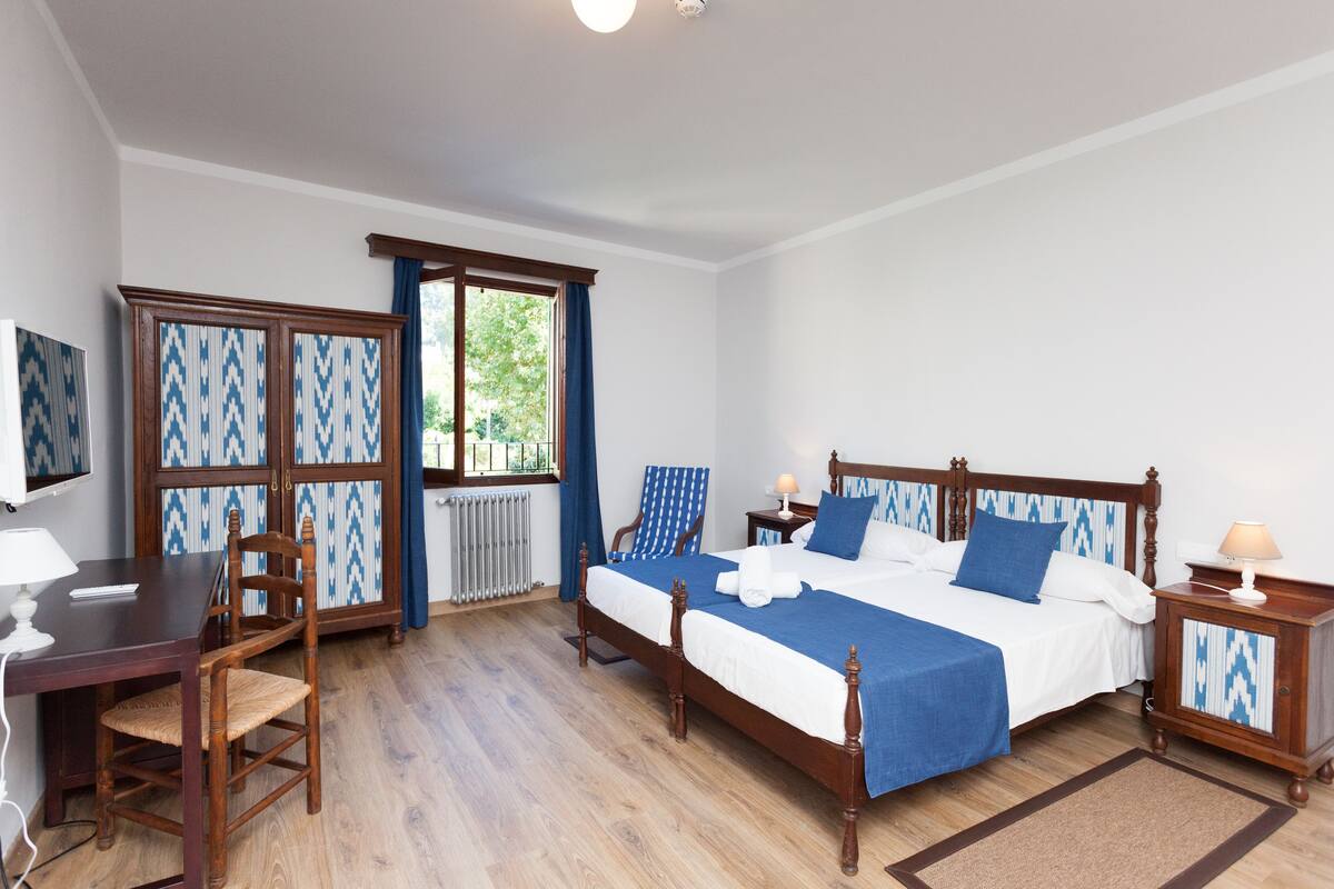 A bedroom with a wooden bed, a desk, and a chair.