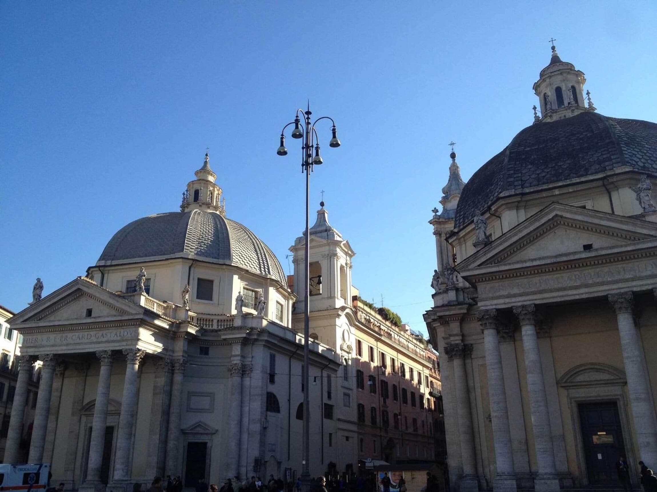 A historic building with classical architecture, including domes and columns, and a clear blue sky.