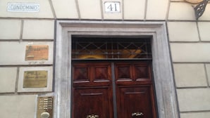 A building entrance with a double wooden door, a plaque indicating 'CONDOMINIO', and a number '41' above the door. - Domus Ripetta (Rome)