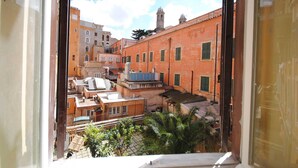 A view from a window overlooking a courtyard with buildings, including a red brick structure with a bell tower. - Domus Ripetta (Rome)