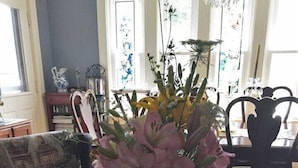 A living room with a glass coffee table, a patterned sofa, and a floral arrangement. - Scotch Hill Inn (Ogunquit)