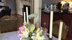 A dining table with a floral centerpiece and candle holders. - Scotch Hill Inn (Ogunquit)