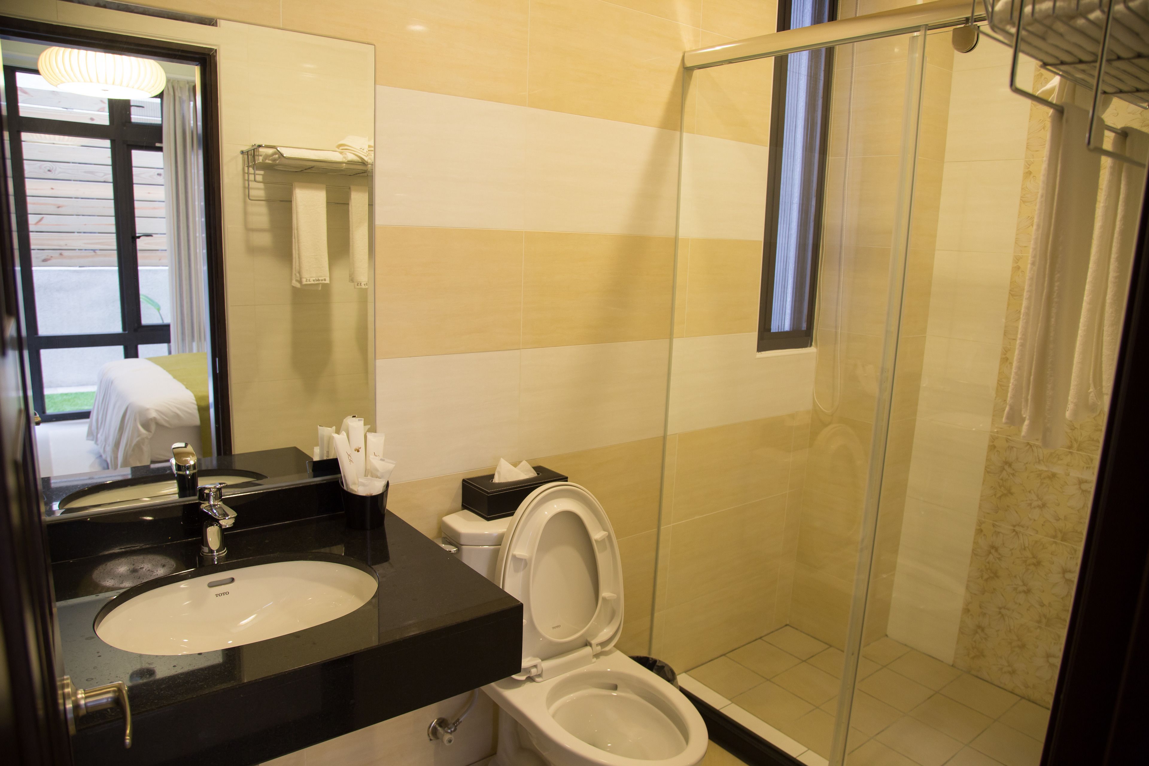 A bathroom with a sink, toilet, and glass shower enclosure.