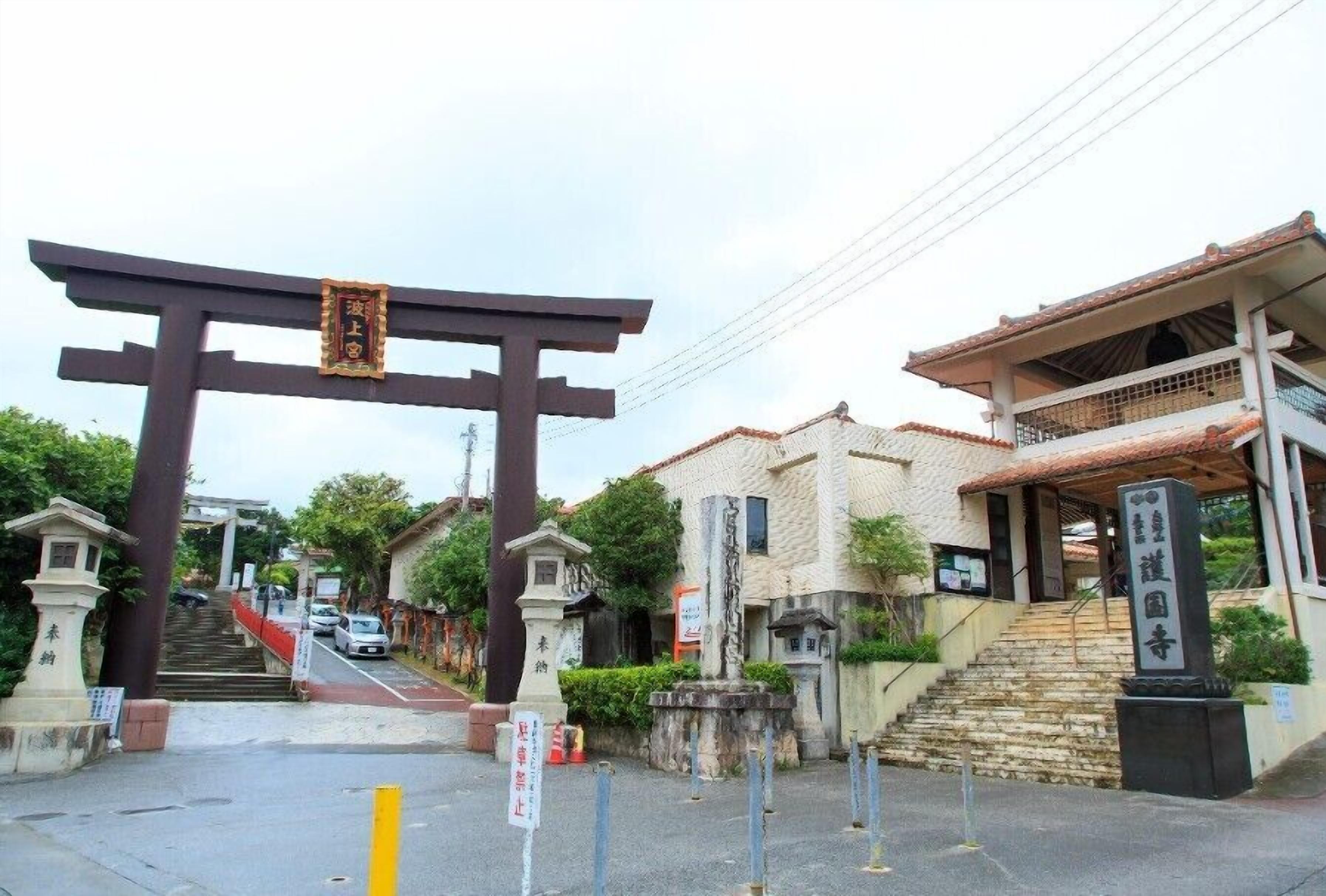 A traditional Japanese torii gate at the entrance of a building with a staircase leading up to it.