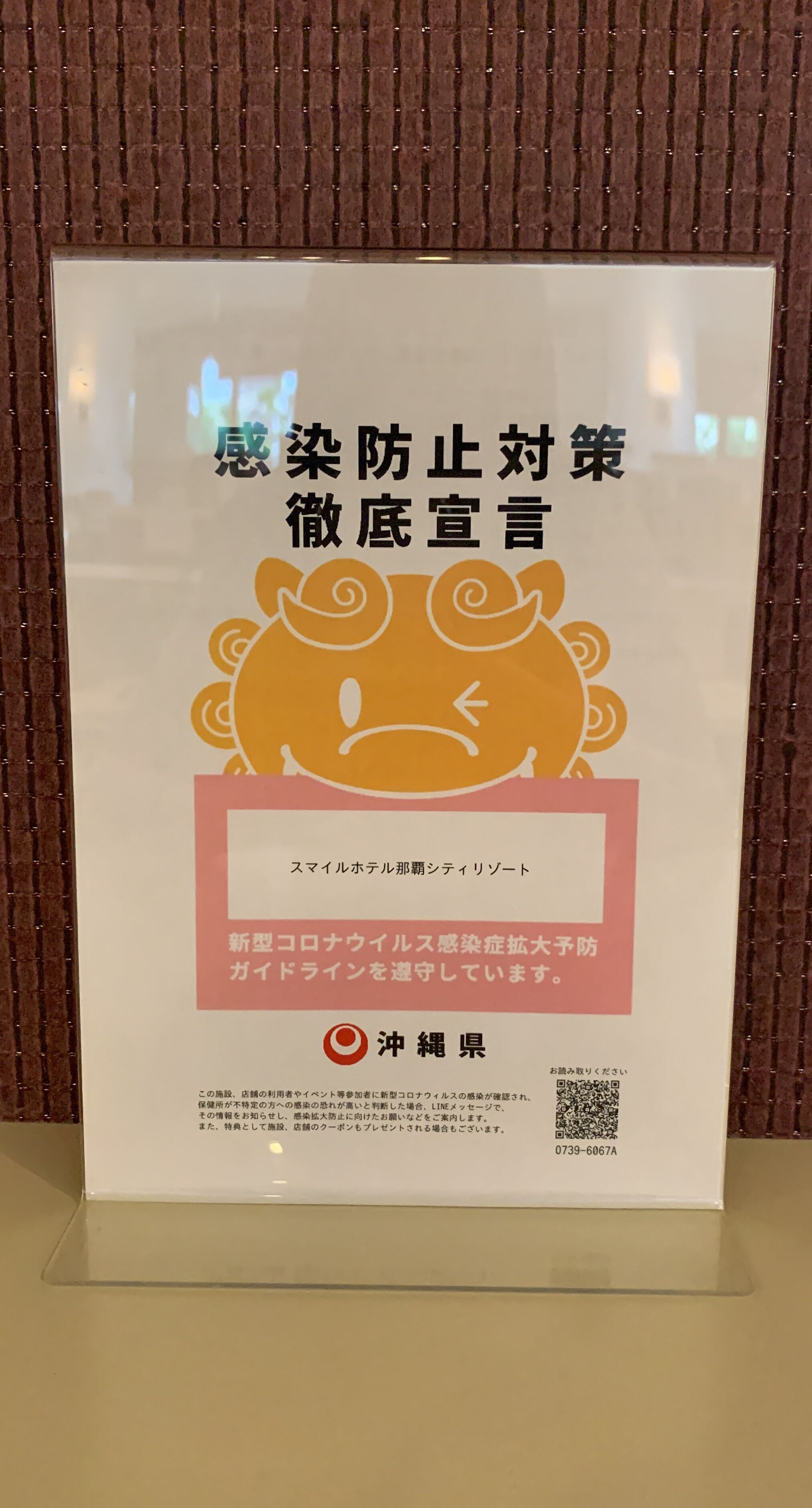 Letrero con texto en japonés y un cerdo caricaturesco, probablemente relacionado con servicios o políticas del hotel.