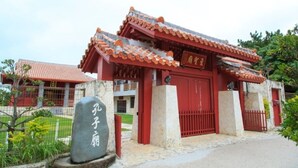 Een traditioneel Chinees gebouw met een rood dak en een grote rode poort.