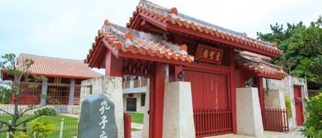 Um edifício tradicional chinês com telhado vermelho e um grande portão vermelho.