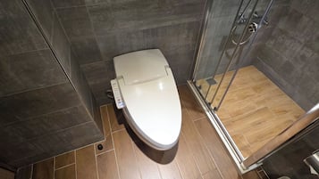 Ein modernes Badezimmer mit Toilette, Duschkabine und Holzboden.