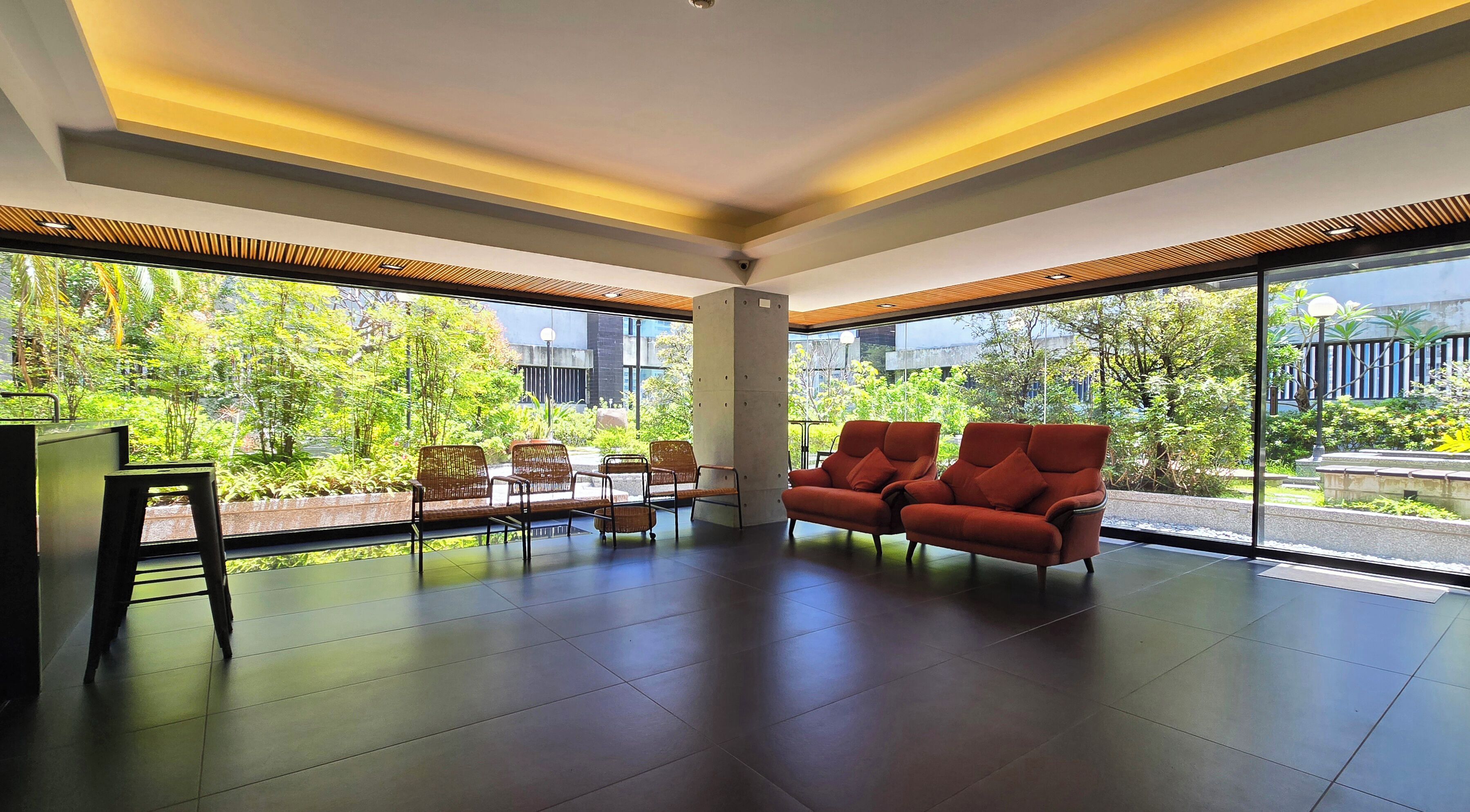 A spacious room with a large window, a sofa, and a coffee table.