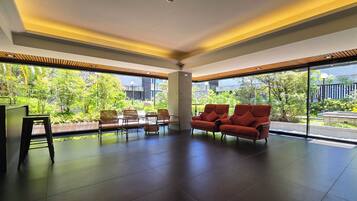 A spacious room with a large window, a sofa, and a coffee table.
