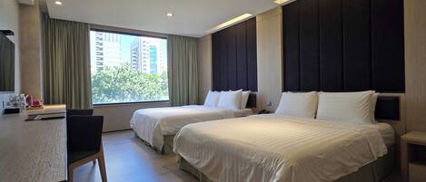 A hotel room with two beds, a desk, and a chair.