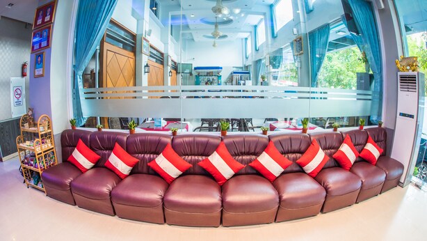 A modern hotel lobby with a curved seating area, large windows, and a view of the dining area. - Diamond Crown Hotel (Yangon)