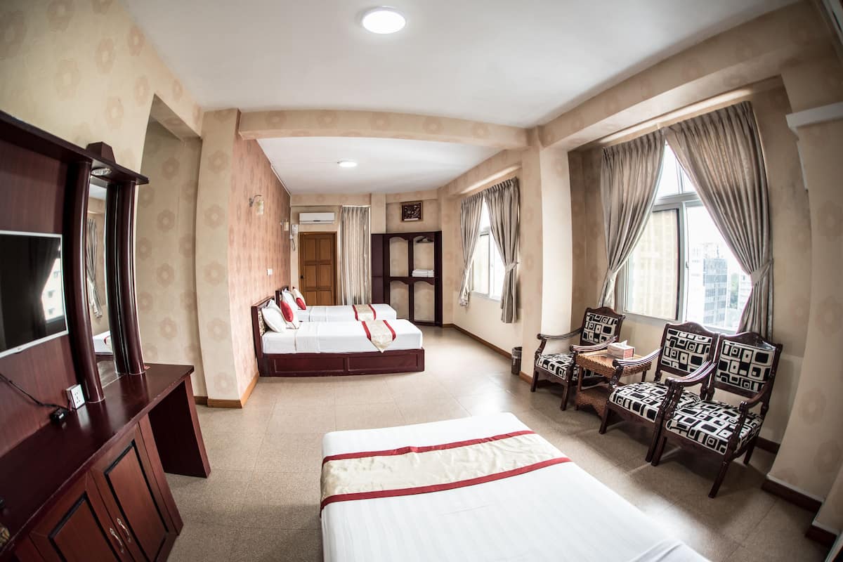 A hotel room with two beds, a TV, a desk, and a chair.