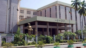 A building with a large statue in front, surrounded by greenery and palm trees. - Diamond Crown Hotel (Yangon)