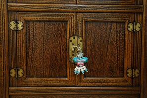Una puerta de madera con un pestillo de latón y un adorno decorativo con forma de mariposa.