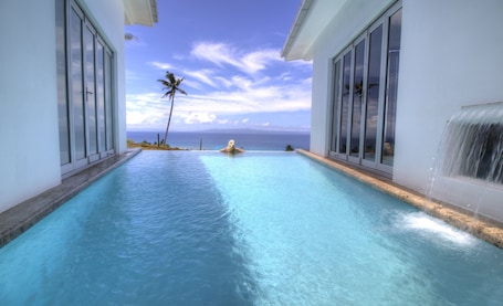 Outdoor pool, an infinity pool, pool umbrellas, sun loungers