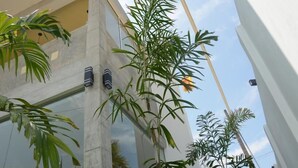 Un edificio moderno con grandes ventanales y columnas verticales.