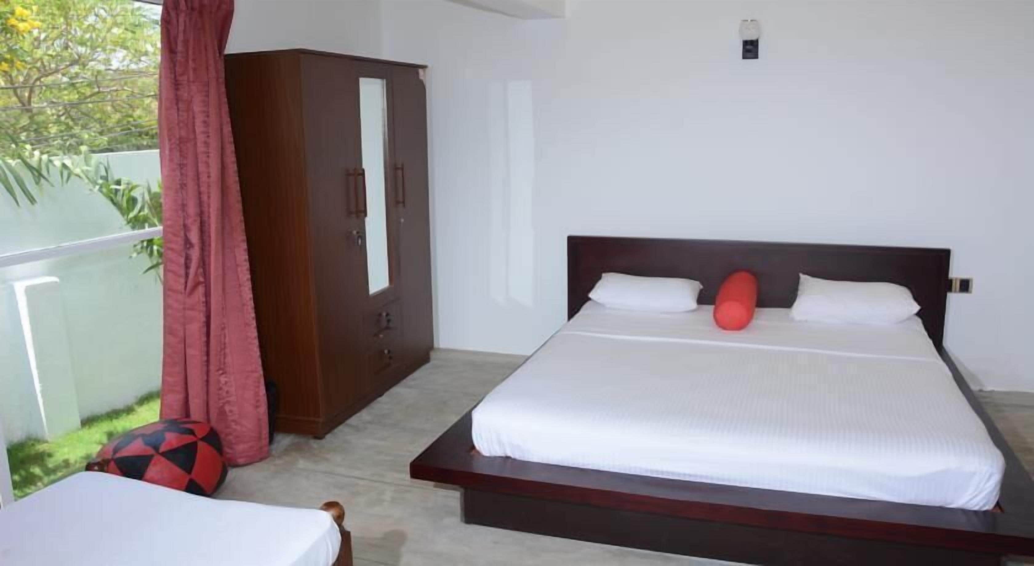 A bedroom with a bed, a wardrobe, and a small table.