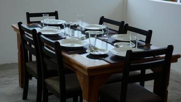 Una mesa de comedor dispuesta con platos, vasos y cubiertos.