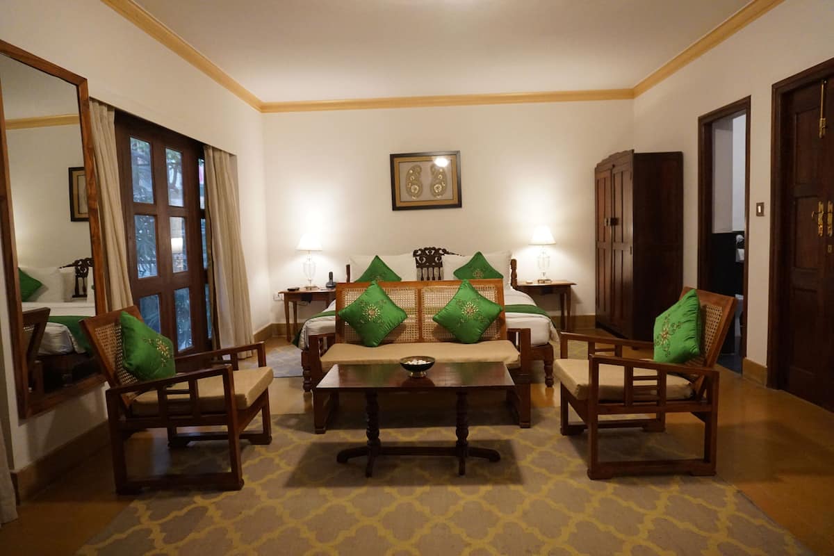 A room with a sofa set, a dining table, and a mirror.