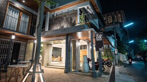 A modern building with a restaurant and a sign indicating a hotel and cafe. - Thapae Happy House (Chiang Mai)