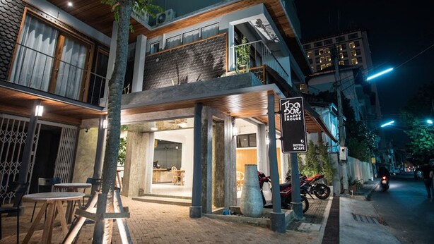 A modern building with a restaurant and a sign indicating a hotel and cafe. - Thapae Happy House (Chiang Mai)