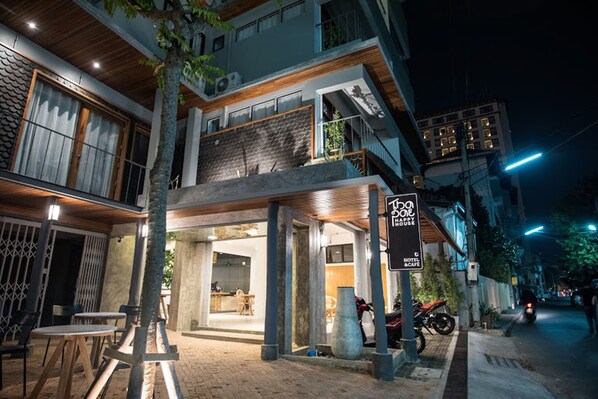 A modern building with a restaurant and a sign indicating a hotel and cafe. - Thapae Happy House (Chiang Mai)