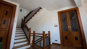 A wooden staircase with a handrail, white walls, and a double door with glass panels. - Hill Pride City Hotel (Nuwara Eliya)