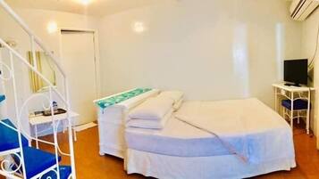 Un dormitorio con cama, escritorio y silla.