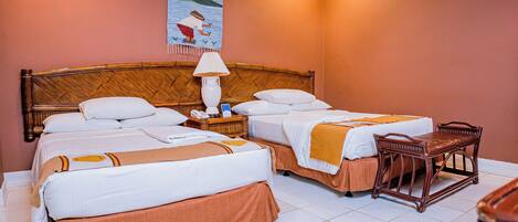 A hotel room with two beds, a nightstand, a lamp, and a wooden chair.