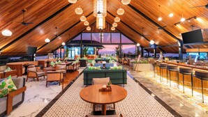 A spacious, modern interior with a high ceiling, wooden beams, and a central seating area with a round table. - Jimbaran Bay Beach Resort & Spa (Kedonganan)