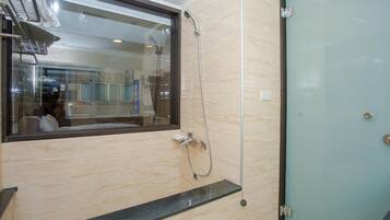 A bathroom with a glass shower enclosure, a mirror, and a sink.
