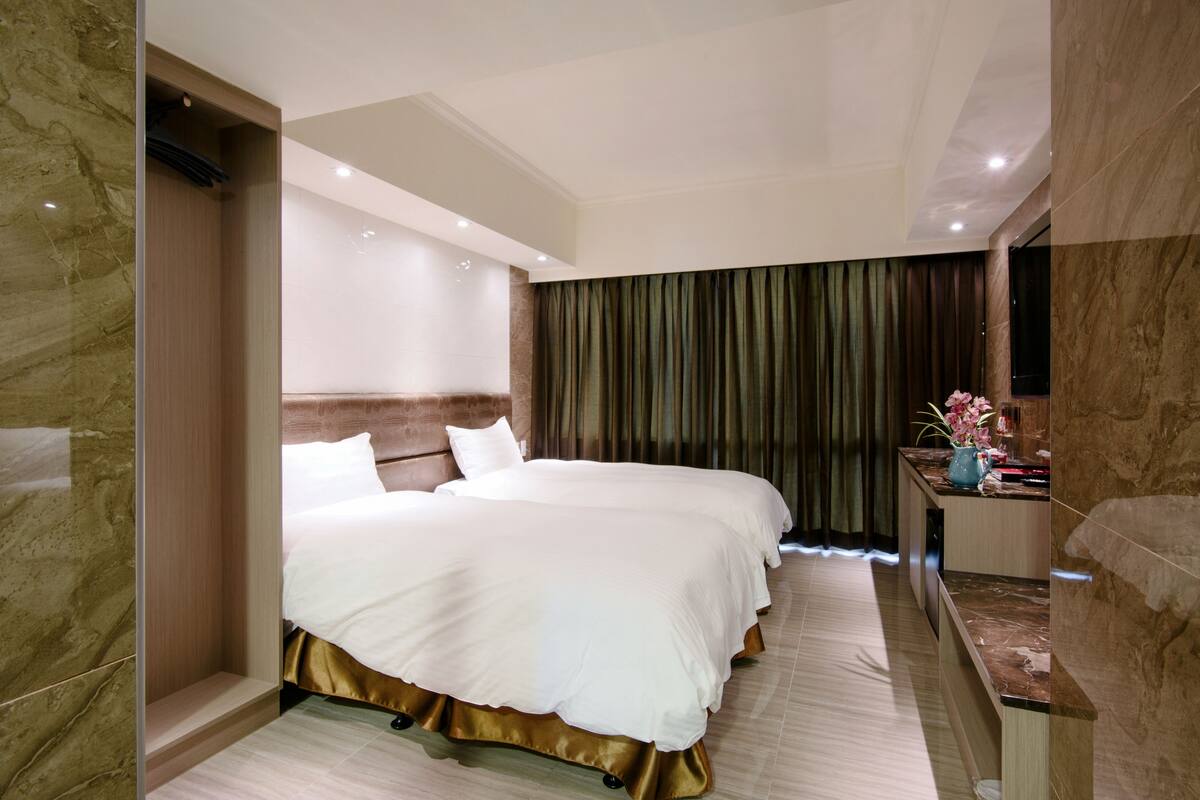 A hotel room with a large bed, a desk, and a bathroom.