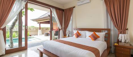 A spacious bedroom with a large bed, a wooden nightstand, and a view of a swimming pool.