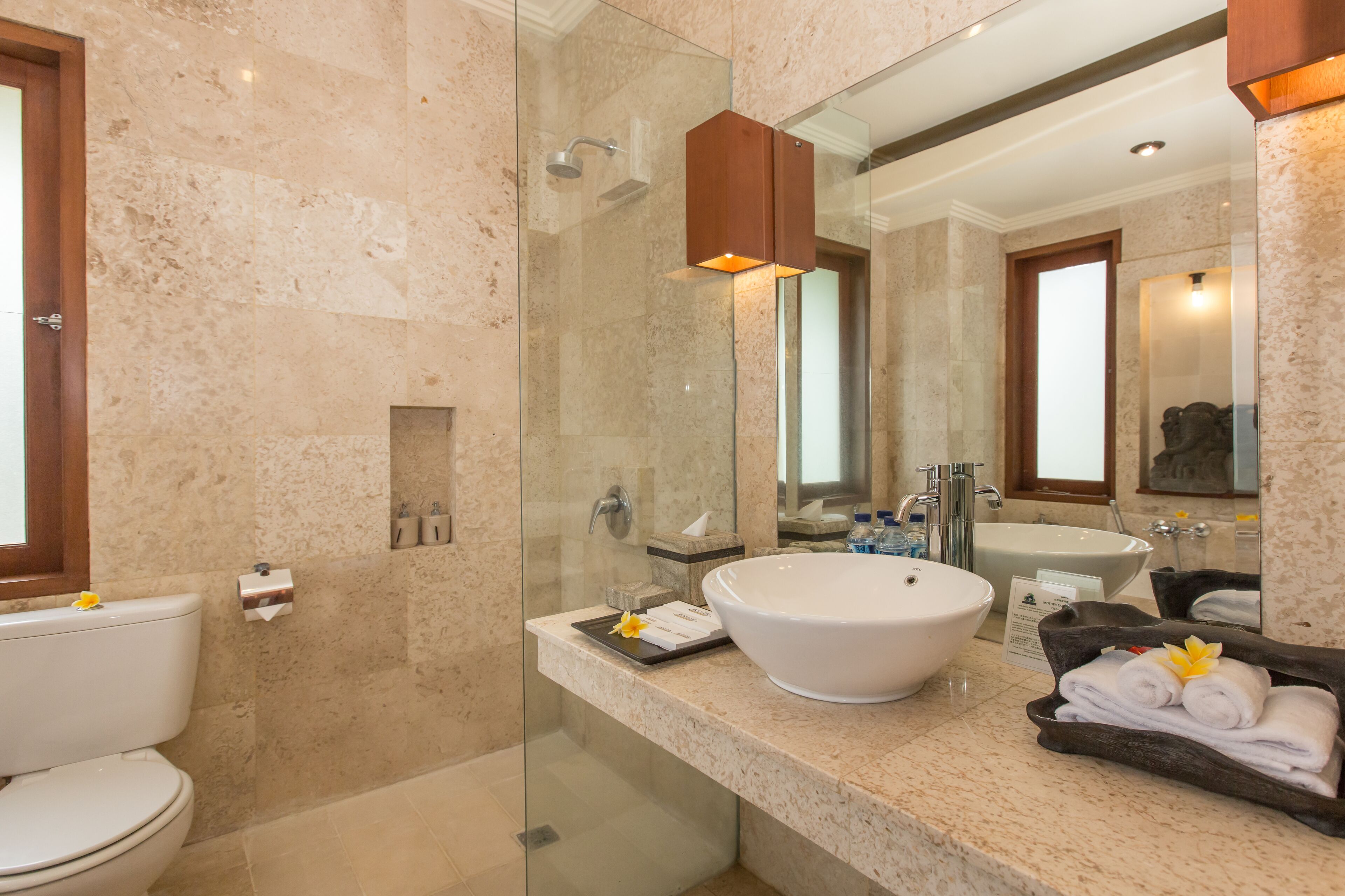 A modern bathroom with a glass-enclosed shower, a large sink, and a mirror.