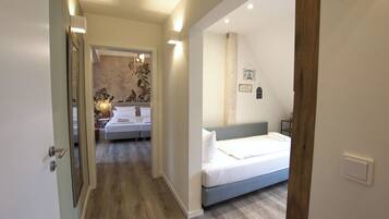 Una habitación de hotel con una cama, una mesita de noche y una lámpara fijada a la pared.