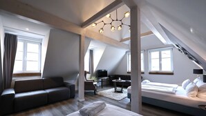Une chambre de style loft moderne, dotée d’un grand lit, d’un canapé et d’un téléviseur.