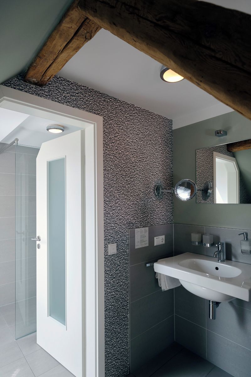 A modern bathroom with a shower, a sink, and a mirror.