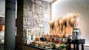 A stone wall with a variety of jars containing different food items and a coffee machine on a counter. - Castello del Sole Beach Resort & SPA (Locarno)