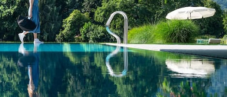 Una piscina cubierta, una piscina al aire libre de temporada, sombrillas