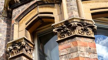 A close-up of a building's corner with ornate stone carvings and brickwork.