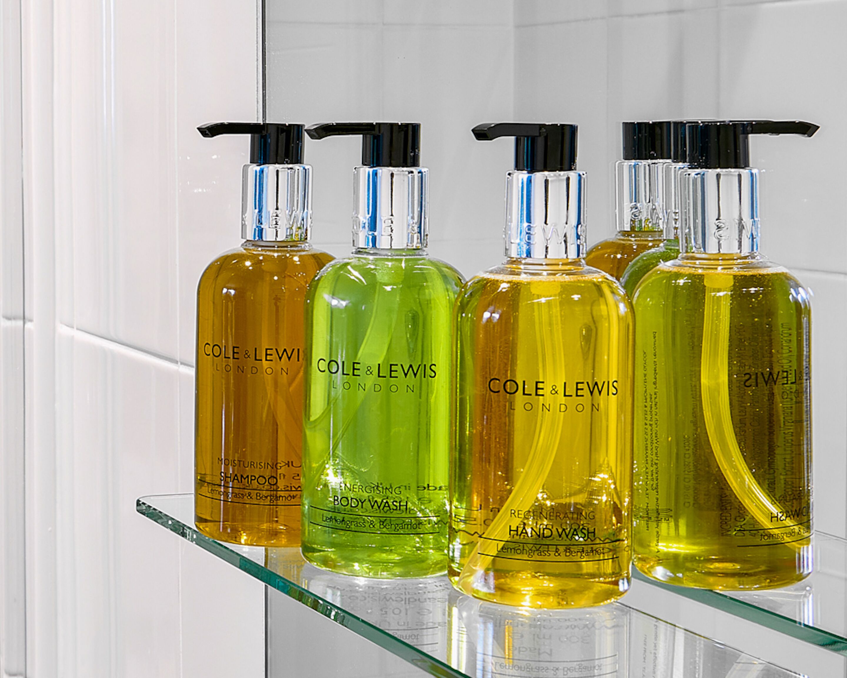 Four bottles of Cole & Lewi London hand wash on a glass shelf.