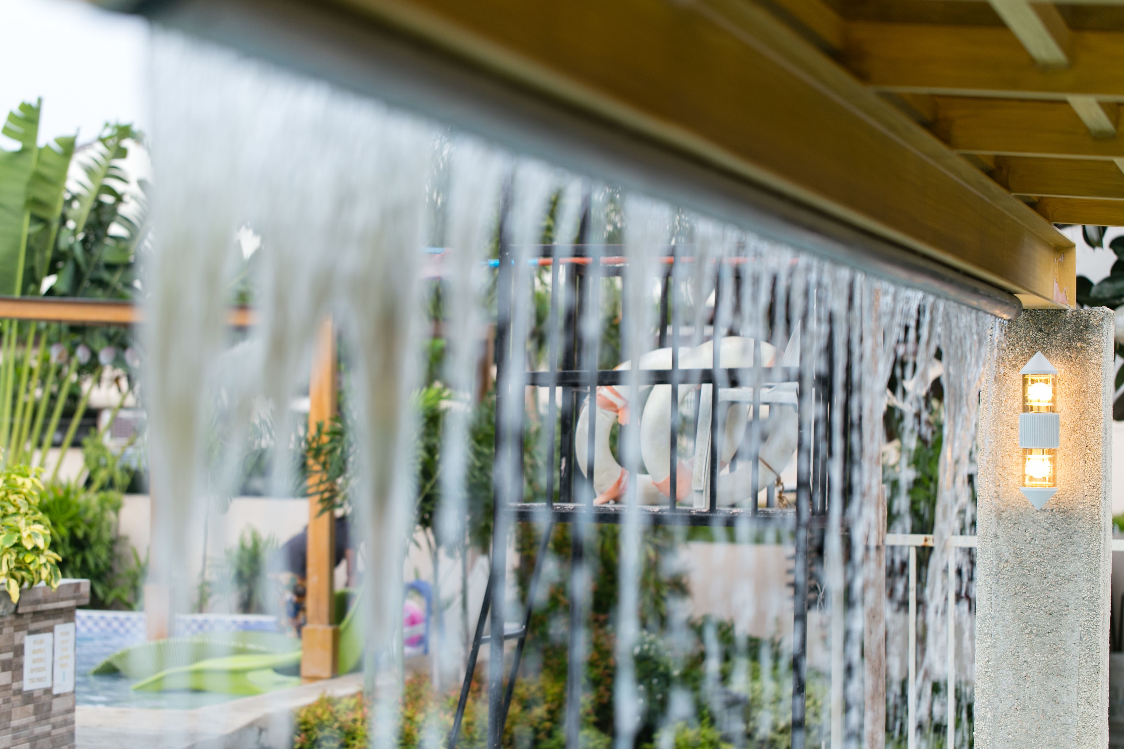 A water feature with a fountain and a seating area with a view of the surrounding garden.