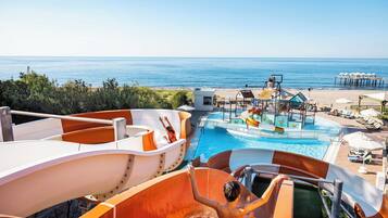 Enjoy the ocean views from our water park, featuring slides and a pool area with lounge chairs and umbrellas.