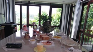 Una mesa de comedor preparada con distintos platos, un control remoto y una jarra.